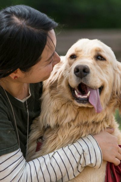 A Women Holds Her Dog and looking at dogs Face